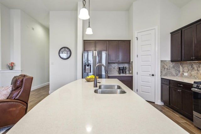 kitchen featuring backsplash, sink, hanging light fixtures, and stainless steel appliances