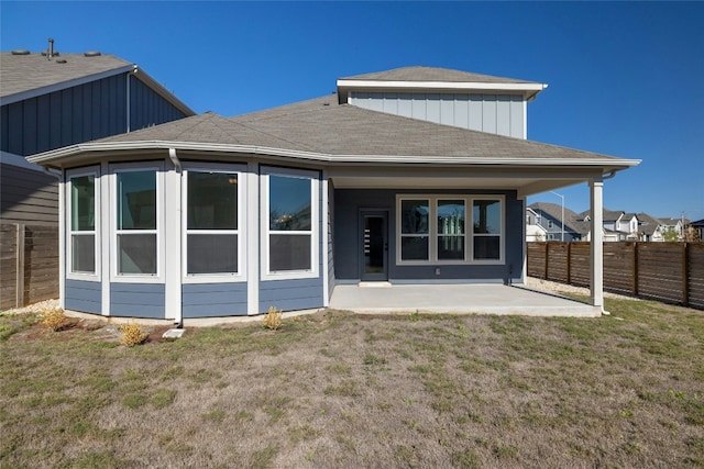 rear view of house featuring a yard and a patio