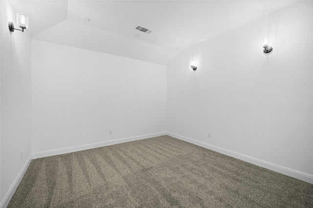 empty room with carpet and vaulted ceiling