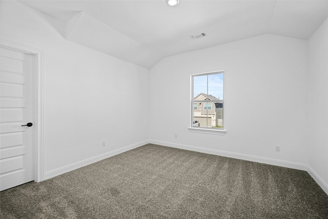 empty room featuring carpet floors and vaulted ceiling