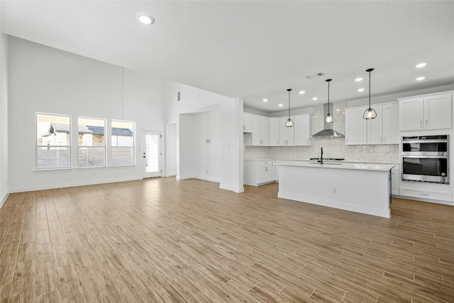 unfurnished living room with light hardwood / wood-style flooring and sink