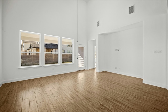 unfurnished living room featuring a towering ceiling