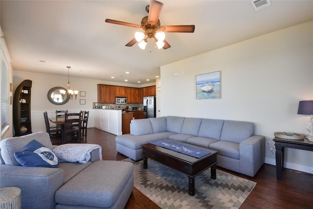 living room featuring dark hardwood / wood-style flooring and ceiling fan with notable chandelier