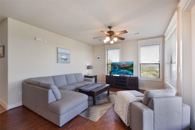 living room featuring ceiling fan and dark wood-type flooring