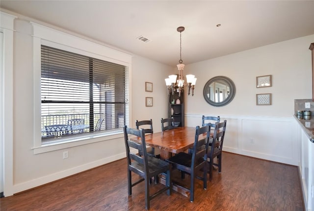 dining space with an inviting chandelier and dark wood-type flooring