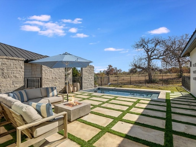 view of pool featuring a patio area and an outdoor living space with a fire pit