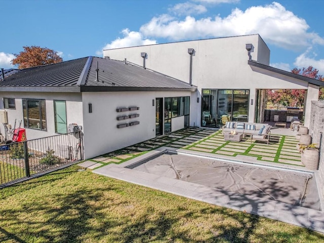 rear view of property featuring outdoor lounge area, a yard, and a patio