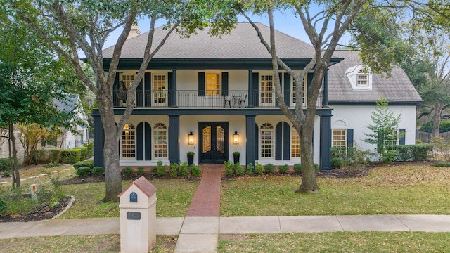 view of front of property with a balcony, a front lawn, french doors, and a porch