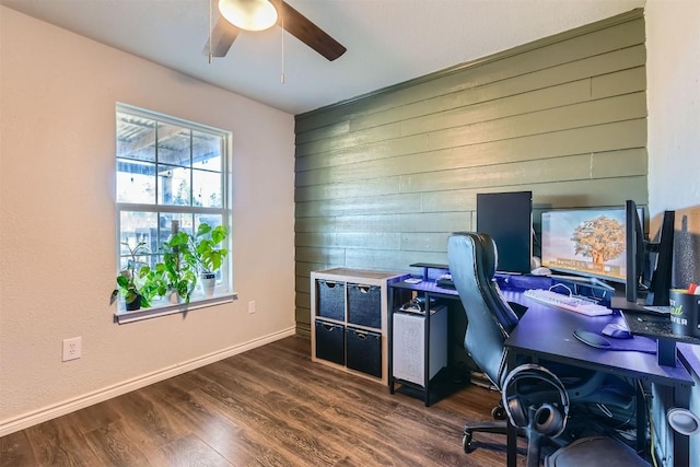 home office featuring wooden walls, dark hardwood / wood-style flooring, and ceiling fan