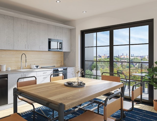 kitchen with sink, white cabinetry, backsplash, and appliances with stainless steel finishes