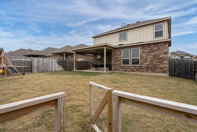 rear view of property featuring a patio, a fenced backyard, a playground, a yard, and brick siding