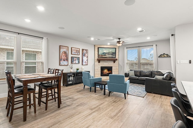 dining area featuring visible vents, recessed lighting, light wood-style floors, a fireplace, and ceiling fan