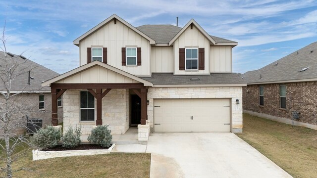 view of front of home featuring a porch, a garage, and a front lawn