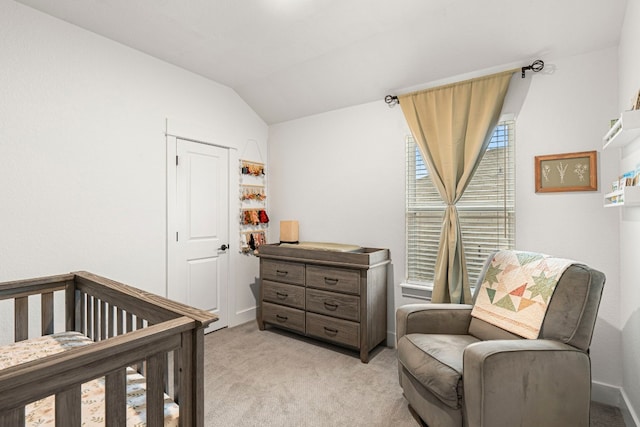 bedroom with light carpet, baseboards, a crib, and lofted ceiling