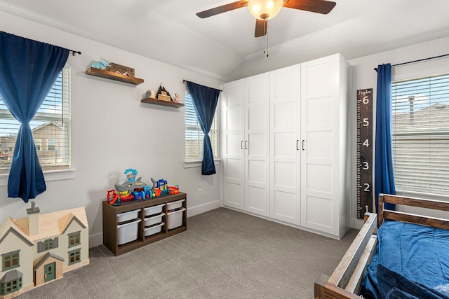 bedroom with a ceiling fan, vaulted ceiling, light colored carpet, and baseboards