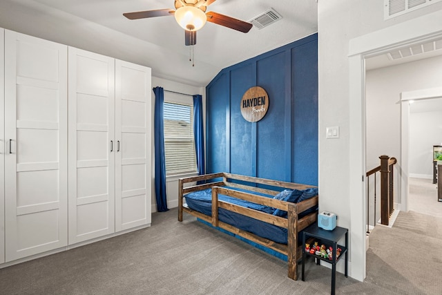 carpeted bedroom with a ceiling fan, visible vents, and baseboards