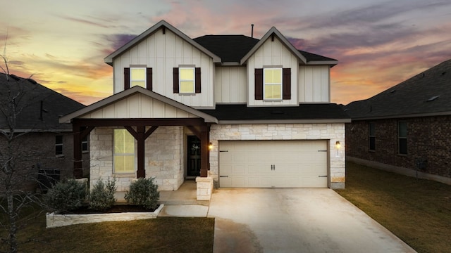 view of front facade with stone siding, board and batten siding, an attached garage, and concrete driveway