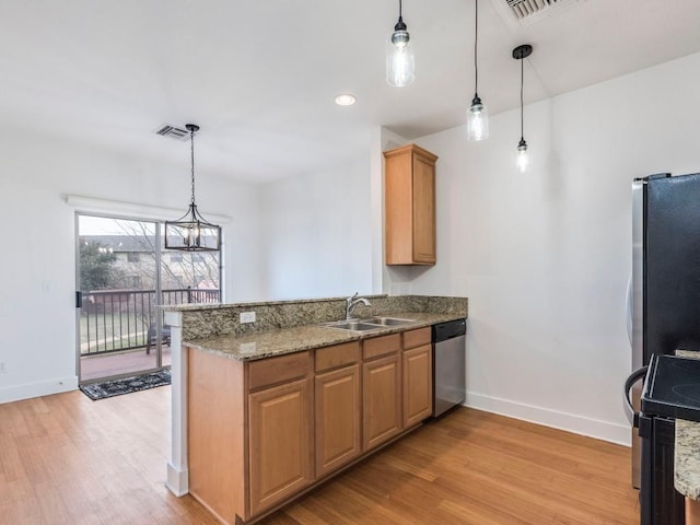 kitchen with kitchen peninsula, appliances with stainless steel finishes, and decorative light fixtures