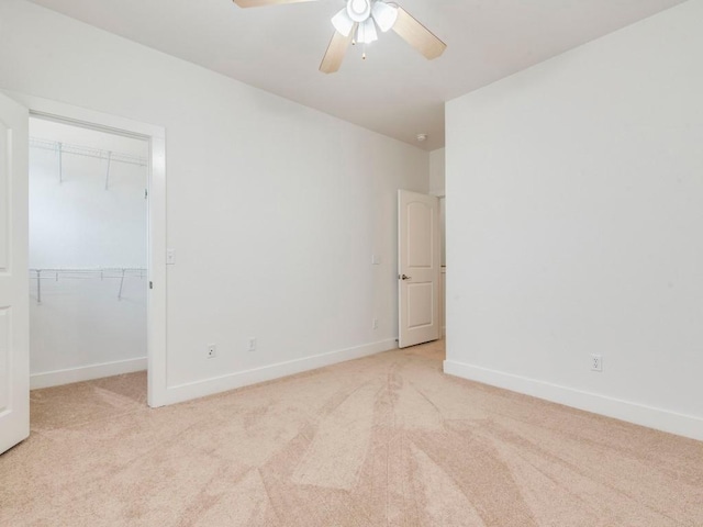 unfurnished bedroom featuring ceiling fan, a closet, and light colored carpet