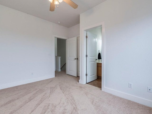 unfurnished bedroom featuring ceiling fan, light colored carpet, and connected bathroom