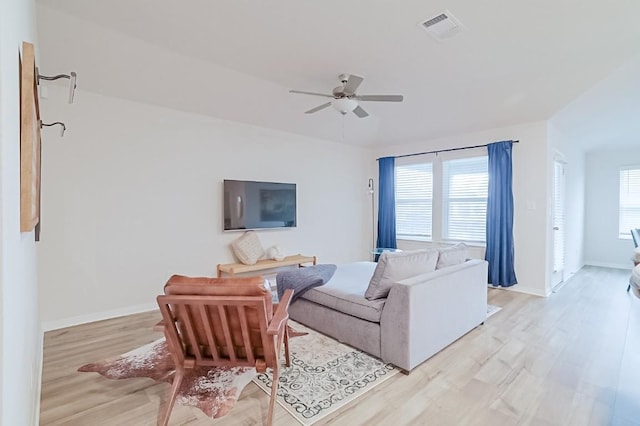 living room featuring light hardwood / wood-style flooring and ceiling fan