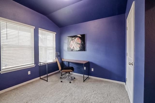 carpeted home office with vaulted ceiling