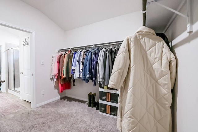 spacious closet with lofted ceiling and carpet floors