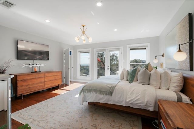 bedroom with dark hardwood / wood-style floors, access to exterior, a chandelier, and french doors