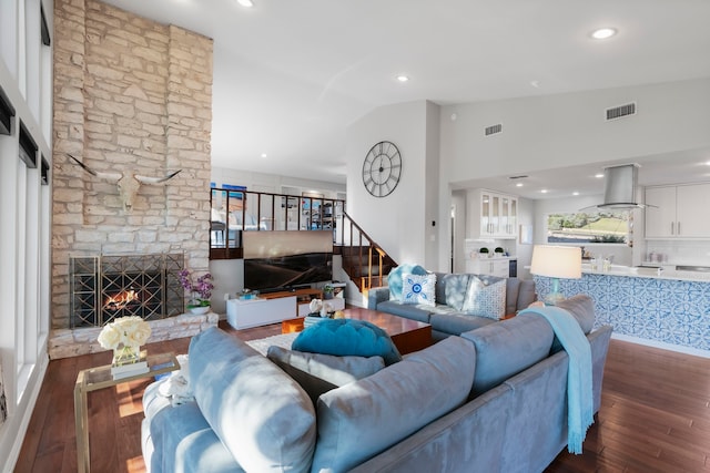 living room with a fireplace, dark wood-type flooring, and vaulted ceiling