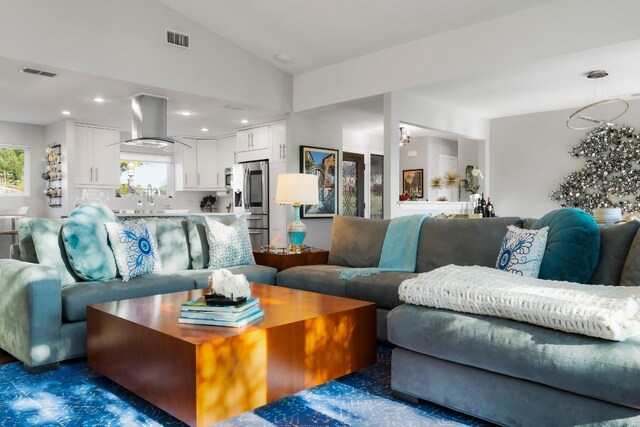 living room featuring lofted ceiling and sink