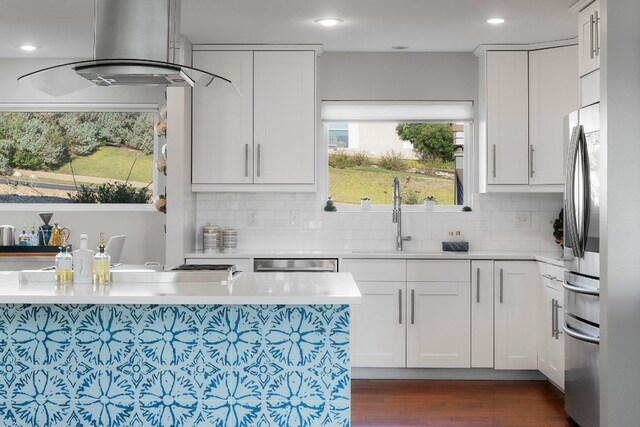 kitchen with sink, appliances with stainless steel finishes, dark hardwood / wood-style floors, island exhaust hood, and white cabinets