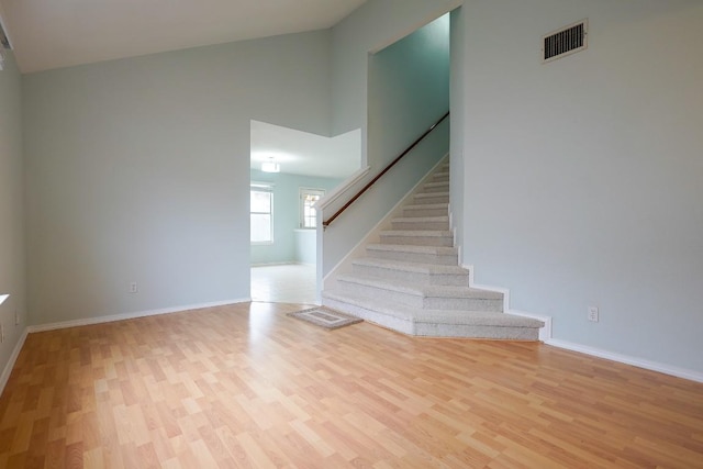 interior space featuring a towering ceiling and hardwood / wood-style flooring