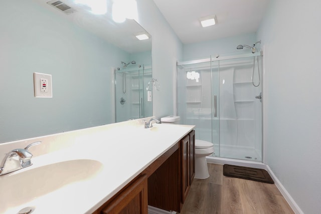 bathroom with toilet, hardwood / wood-style flooring, walk in shower, and vanity