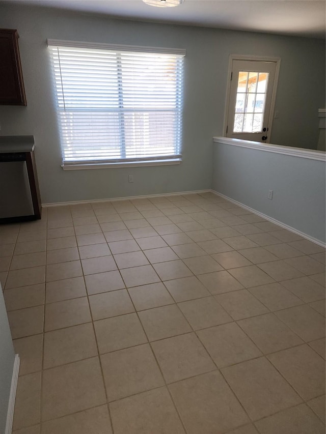 empty room featuring light tile patterned floors and a healthy amount of sunlight