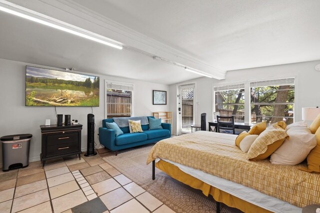 bedroom with light tile patterned floors, access to outside, and beam ceiling