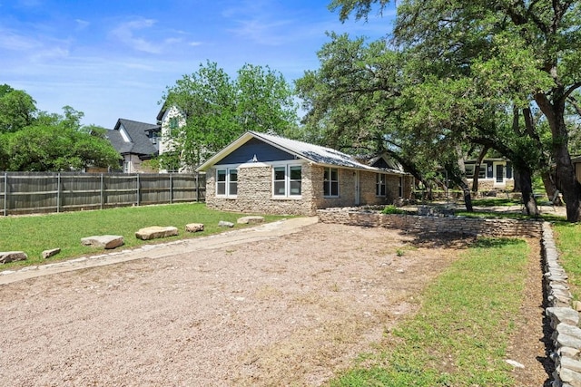 rear view of house with fence and a lawn