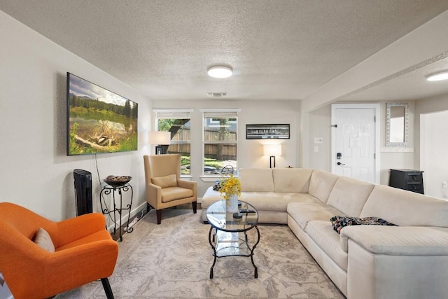 living area with a textured ceiling and visible vents