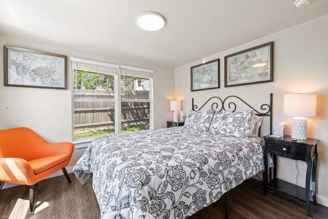 bedroom with dark wood-style flooring and baseboards