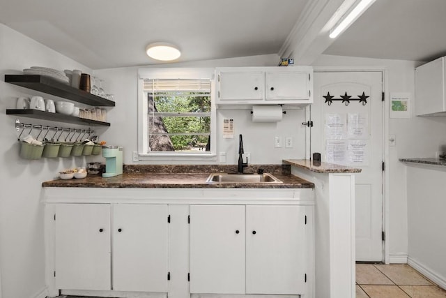 kitchen featuring open shelves, light tile patterned flooring, a sink, and white cabinetry