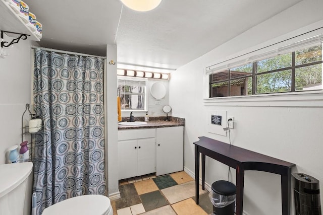 bathroom with toilet, tile patterned floors, and vanity