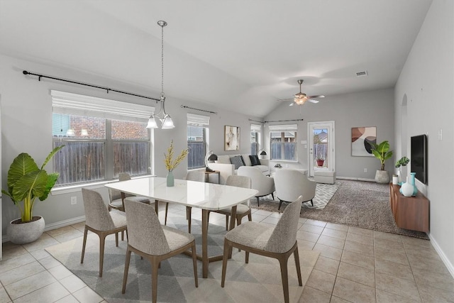 tiled dining space featuring ceiling fan and lofted ceiling