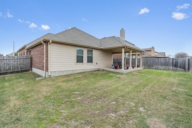 rear view of house featuring a lawn and a patio area