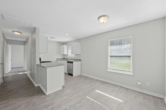 307 E Powell Ln, Austin, TX 78753 - kitchen with dishwasher, sink, kitchen peninsula, light hardwood / wood-style floors, and white cabinetry