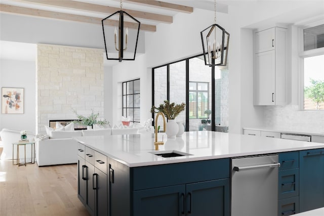 kitchen featuring hanging light fixtures, white cabinetry, light countertops, and a notable chandelier