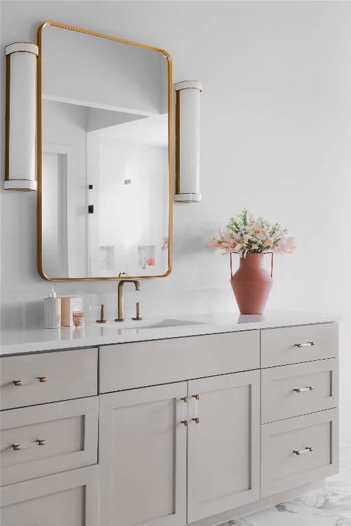 bathroom with marble finish floor and vanity