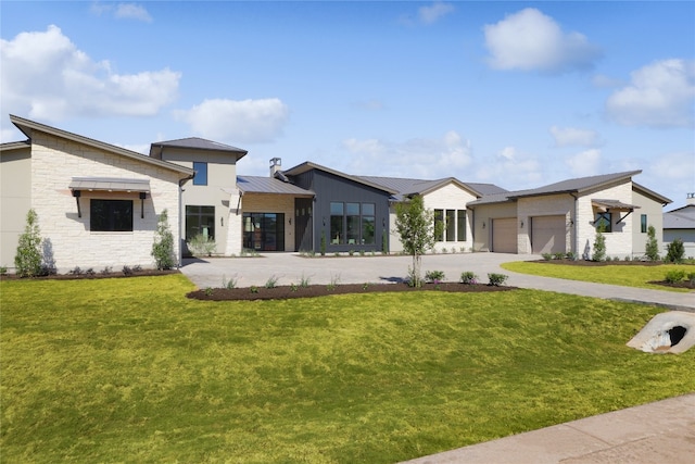 view of front of property with a garage, concrete driveway, metal roof, a standing seam roof, and a front lawn