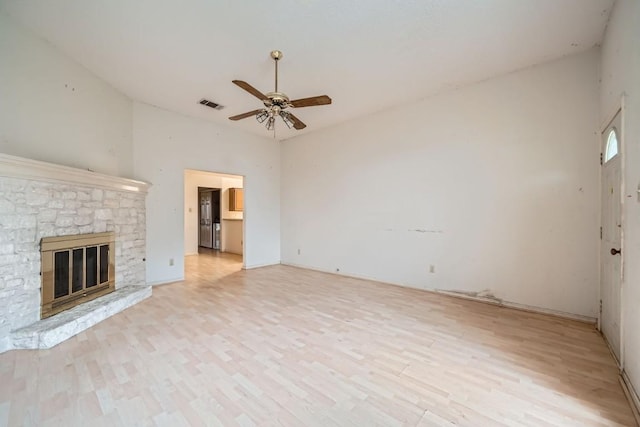 unfurnished living room featuring ceiling fan, a fireplace, and light hardwood / wood-style flooring