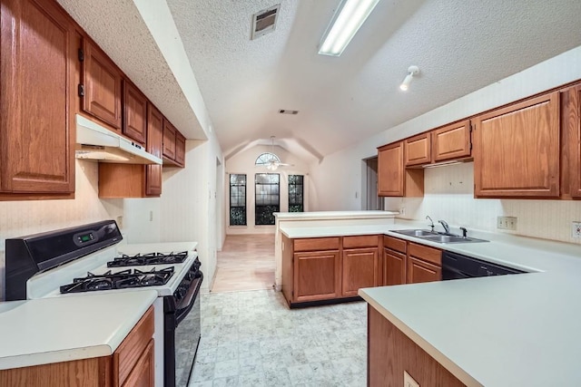 kitchen with kitchen peninsula, a textured ceiling, vaulted ceiling, sink, and white gas stove