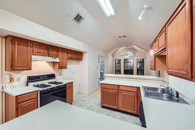 kitchen with a textured ceiling, vaulted ceiling, ceiling fan, sink, and white range with gas stovetop