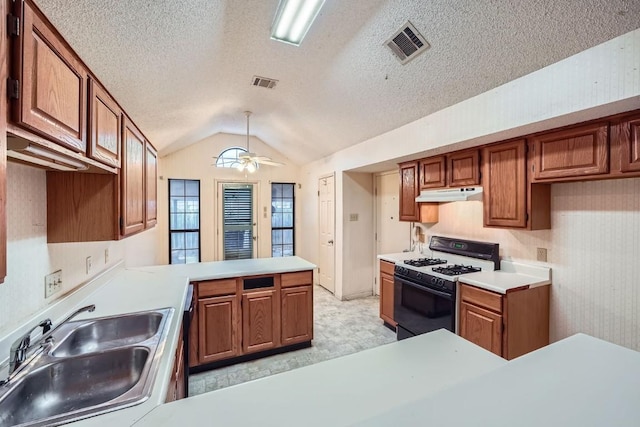 kitchen featuring sink, vaulted ceiling, gas range, ceiling fan, and kitchen peninsula